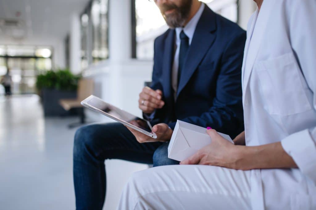 Close up of a man in a suit speaking intimately with another person.