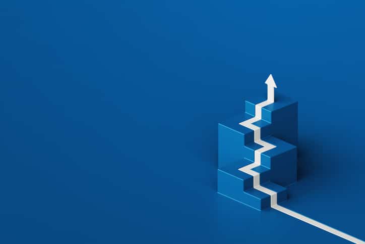 A white arrow is shown climbing a set of blue staircases, showing how emotional intelligence can help your team succeed.
