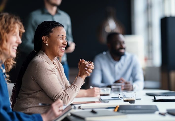 Professionals sharing ideas and engaged in a collaborative meeting around a table in a business setting. Showcases teamwork, communication, and corporate engagement in a modern office environment.
